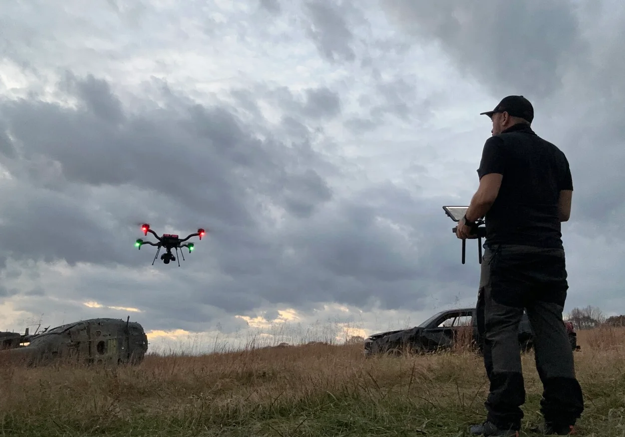 Drone operator piloting a camera drone in the field